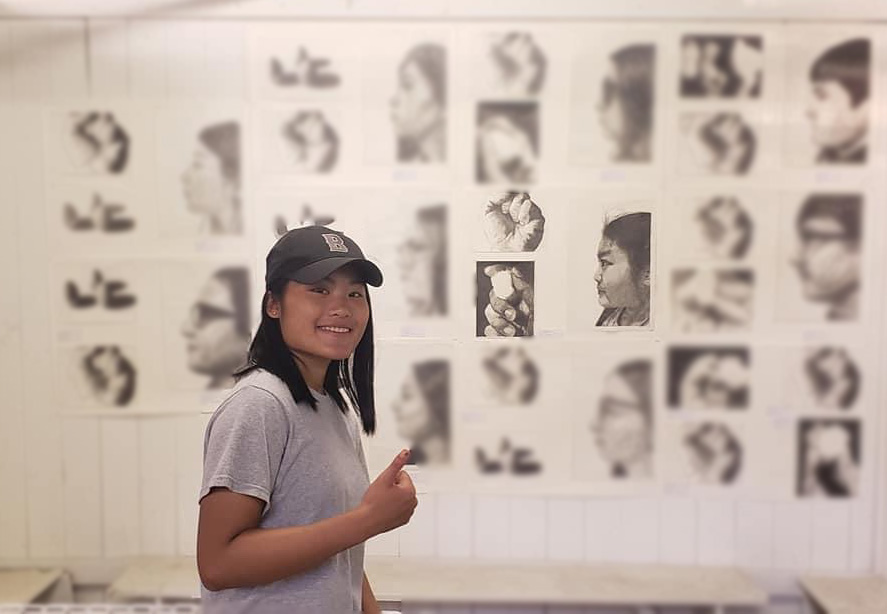 Angel Logemann with her artwork display at an art show